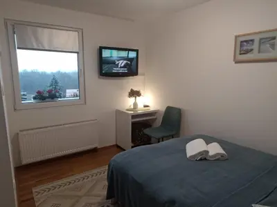 a bedroom with a bed and a television on a window at Holiday House with scenic Apartment in Ptuj