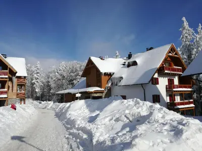 a pile of snow in front of a building at Holiday Apartment Bolfenk in Pohorje