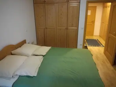 a bedroom with a bed with a green blanket at Holiday Apartment Bolfenk in Pohorje