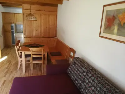 a room with a table and a couch and a kitchen at Holiday Apartment Bolfenk in Pohorje