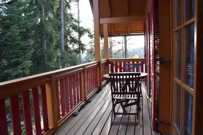 a porch with two chairs and a table on it at Holiday Apartment Bolfenk in Pohorje