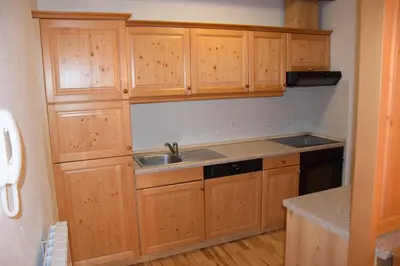 a kitchen with wooden cabinets and a sink at Holiday Apartment Bolfenk in Pohorje