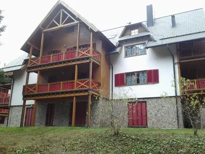 a large wooden building with red balconies on it at Holiday Apartment Bolfenk in Pohorje