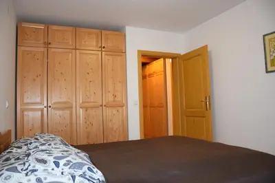 a bedroom with a bed and some wooden cabinets at Holiday Apartment Bolfenk in Pohorje