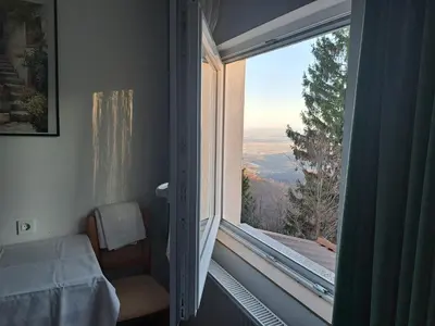 a bedroom with a window with a view of the mountains at Gostišče Jelka in Pohorje