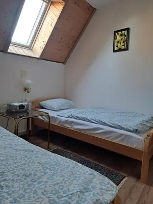 a room with two beds and a window at Gostišče Jelka in Pohorje