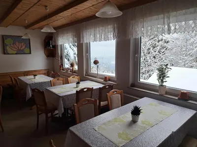 a restaurant with tables and chairs and a window at Gostišče Jelka in Pohorje