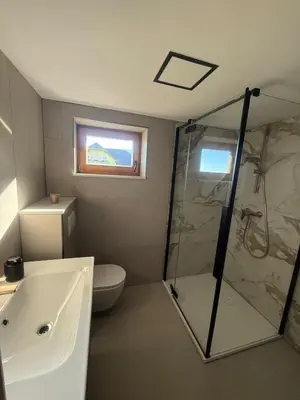 a bathroom with a shower and a toilet and a sink at Private Forest Cabin with Epic View in Ribnica na Pohorju