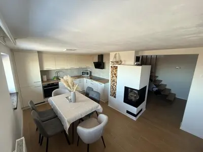 a kitchen and dining room with a table and chairs at Private Forest Cabin with Epic View in Ribnica na Pohorju