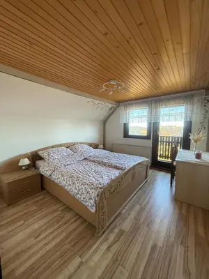 a bedroom with a bed and a wooden ceiling at Private Forest Cabin with Epic View in Ribnica na Pohorju