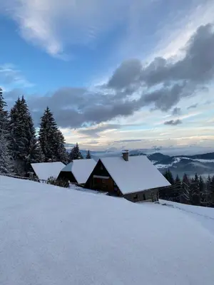 a house covered in snow on top of a mountain at Private Forest Cabin with Epic View in Ribnica na Pohorju