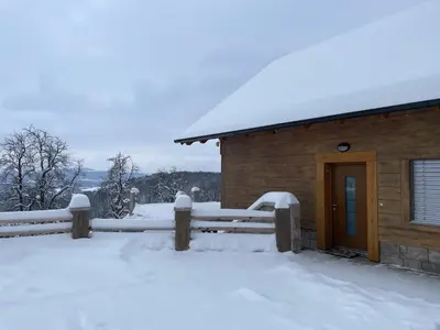a house covered in snow next to a fence at Zerko Holiday Apartment MARJETKA with WELLNESS bookable separately in Mirna