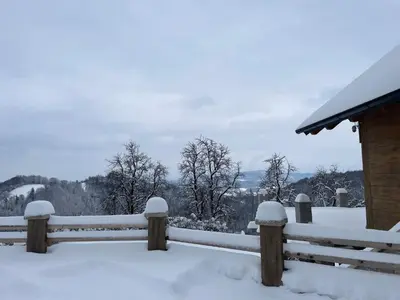 a fence covered in snow next to a house at Zerko Holiday Apartment MARJETKA with WELLNESS bookable separately in Mirna