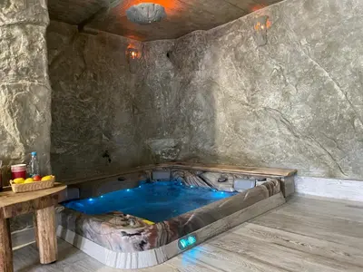 a jacuzzi tub in a room with a stone wall at Zerko Holiday Apartment MARJETKA with WELLNESS bookable separately in Mirna