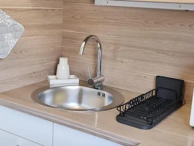 a kitchen counter with a sink with a laptop on it at EMIA Family House Čatež in Brežice