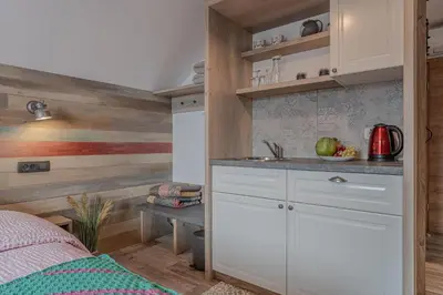 a kitchen with white cabinets and a sink in a room at Lukec Estate in Kostel