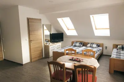 a bedroom with a bed and a table with chairs at Apartment and rooms Maraton in Kranjska Gora
