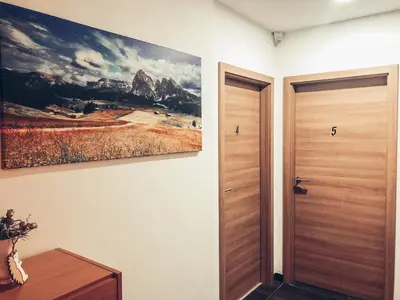 a hallway with a painting on the wall next to a door at Apartment and rooms Maraton in Kranjska Gora