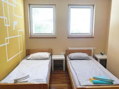 two beds in a room with two windows at Apartment and rooms Maraton in Kranjska Gora