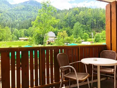 a balcony with a table and chairs and a view of a mountain at Apartment and rooms Maraton in Kranjska Gora