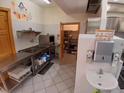 a large kitchen with a sink and a sink at Tau Forest Lodge in Solkan
