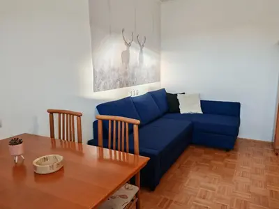 a living room with a blue couch and a table at Apartma Roglina in Zreče