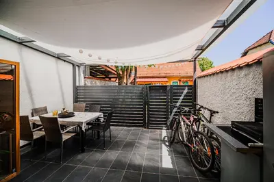 a patio with a table and chairs and a bike at Holiday Home Tinkara with IR Sauna in Čatež ob Savi