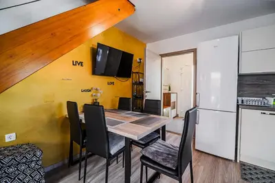 a kitchen and dining room with a table and a refrigerator at Holiday Home Tinkara with IR Sauna in Čatež ob Savi