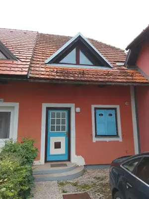 a red and blue house with a blue door at Julijana's Holiday Home in Brežice