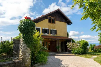 a yellow house with a red flower on top of it at Holiday Home with BBQ in Novo mesto 54727 in Novo Mesto