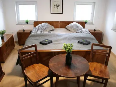 a bedroom with a bed and a table and chairs at Holiday Home with A - C in Zgornji Leskovec 54833 in Zgornji Leskovec