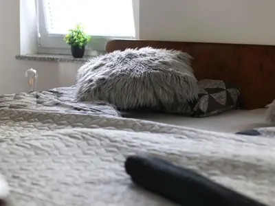 a bedroom with a bed with a fur pillow and a window at Holiday Home with A - C in Zgornji Leskovec 54833 in Zgornji Leskovec