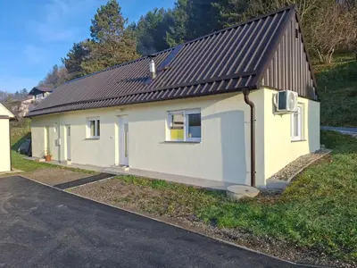 a small white house with a brown roof at Apartma Dividenda in Ptuj