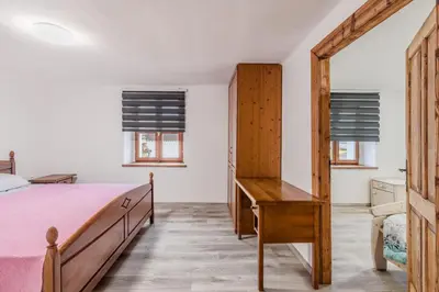 a bedroom with a bed and a desk and windows at Holiday Home Pr'Lukčevih with 4 Bedrooms & Indoor Sauna in Kanal