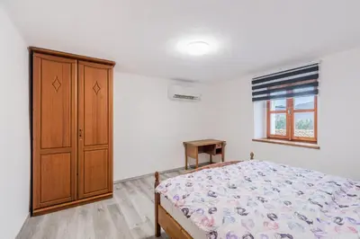 a bedroom with a bed and a wooden cabinet at Holiday Home Pr'Lukčevih with 4 Bedrooms & Indoor Sauna in Kanal