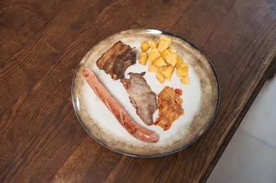 a plate of food with two hot dogs and other foods at Holiday Home Pr'Lukčevih with 4 Bedrooms & Indoor Sauna in Kanal