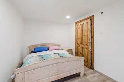 a bedroom with a wooden bed and a wooden door at Holiday Home Pr'Lukčevih with 4 Bedrooms & Indoor Sauna in Kanal