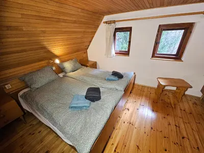 a bedroom with a bed in a wooden house at Hiška Polhec in Bovec