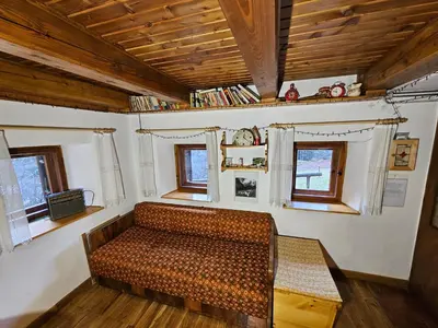 a room with a couch in a room with windows at Hiška Polhec in Bovec