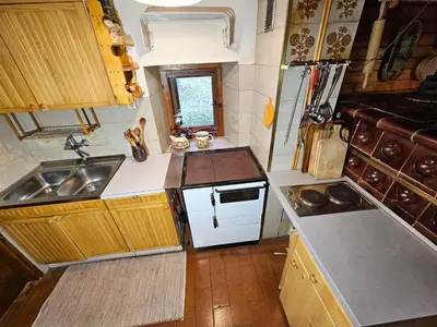 a small kitchen with a sink and a stove at Hiška Polhec in Bovec