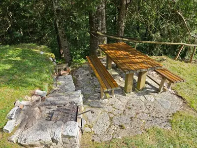a wooden bench sitting on top of a rock at Hiška Polhec in Bovec