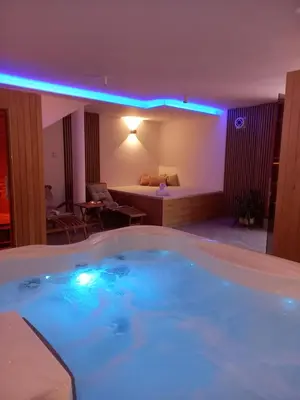 a large bath tub with blue lights in a room at Tourist Farm Arbajter in Resnik