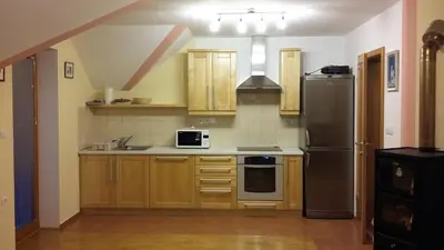 a kitchen with wooden cabinets and a black refrigerator at Tourist Farm Arbajter in Resnik