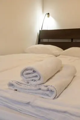 a stack of towels sitting on a bed at AMS Rooms in Ljubljana
