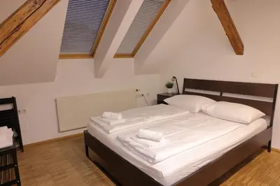 a bedroom with a bed with white sheets and pillows at AMS Rooms in Ljubljana