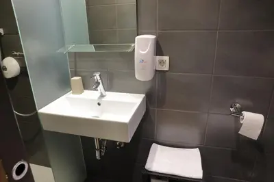 a bathroom with a white sink and a mirror at AMS Rooms in Ljubljana