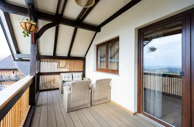 a balcony with two chairs and a large window at Apartment Angelina in Metlika