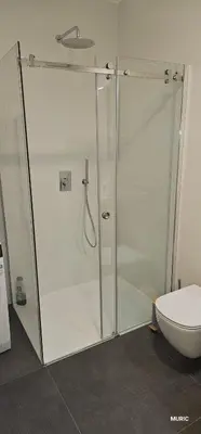 a glass shower stall in a bathroom with a toilet at APARTMENTS MURIC LJubljana in Ljubljana