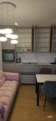 a living room with a couch and a table and a kitchen at APARTMENTS MURIC LJubljana in Ljubljana