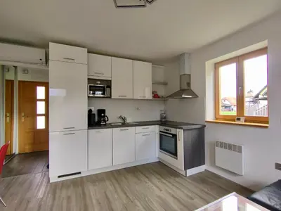 an empty kitchen with white cabinets and a window at Villa Petz in Brežice